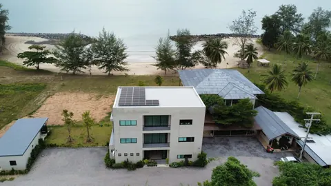 ภาพมุมสูงบ้านสองชั้นและโรงจอดรถที่ติดแผงโซล่าเซลล์