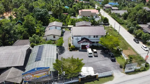 ภาพมุมสูงบ้านในชุมชนที่ติดแผงโซล่าเซลล์บนหลังคา
