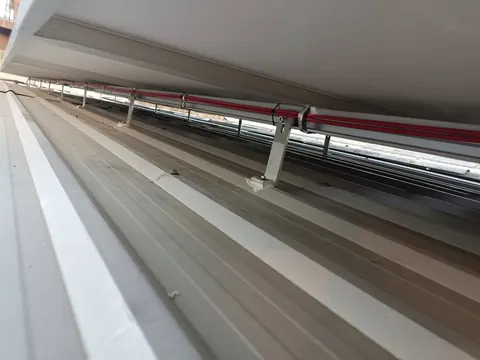 ท่อร้อยสายไฟเดินตามแนวสันหลังคาเมทัลชีทสีขาว