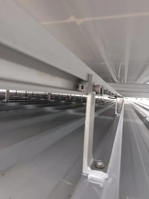โครงเหล็กรับหลังคาและแนวเดินสายไฟภายในอาคารสีขาว