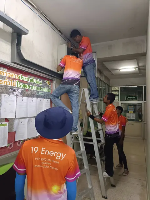 ช่างขึ้นบันไดเดินระบบไฟฟ้าภายในร้านค้าระหว่างติดตั้ง