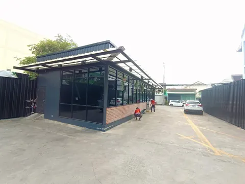 อาคารพาณิชย์โครงเหล็กสีดำริมถนนที่ใช้ระบบโซล่าเซลล์