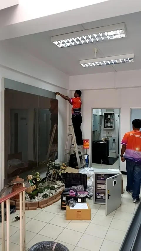 ช่างขึ้นบันไดเดินสายไฟและติดตั้งตู้ควบคุมภายในบ้านพักอาศัย