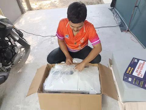ช่างนั่งแกะกล่องอุปกรณ์ระบบโซล่าเซลล์บนดาดฟ้าก่อนเริ่มติดตั้ง