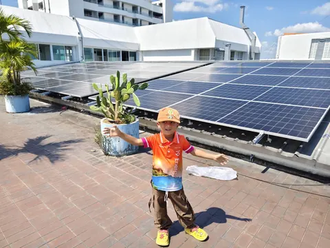 ช่างกำลังยกแผงโซล่าเซลล์ขึ้นติดตั้งบนดาดฟ้าอาคาร