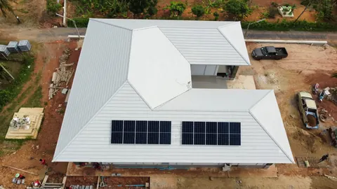 ภาพมุมสูงบ้านหลังคาสีขาวติดแผงโซล่าเซลล์ในโครงการที่กำลังก่อสร้าง