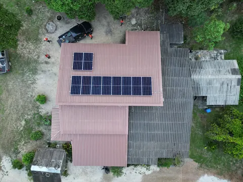 ภาพมุมสูงบ้านหลังคาสีชมพูที่ติดแผงโซล่าเซลล์
