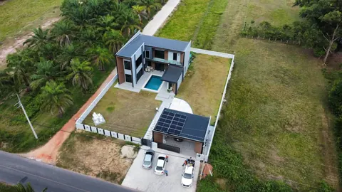 ภาพมุมสูงบ้านพักอาศัยที่ติดแผงโซล่าเซลล์บนหลังคาริมถนนในชนบท