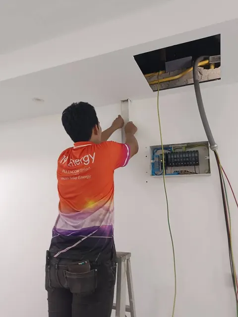 ช่างกำลังติดตั้งอุปกรณ์ควบคุมบนผนังสูงภายในอาคาร โดยทีมช่าง 19Energy
